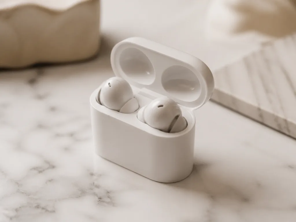 Premium trådlösa in-ear earbuds i ett minimalistiskt laddningsetui på en ljus marmoryta